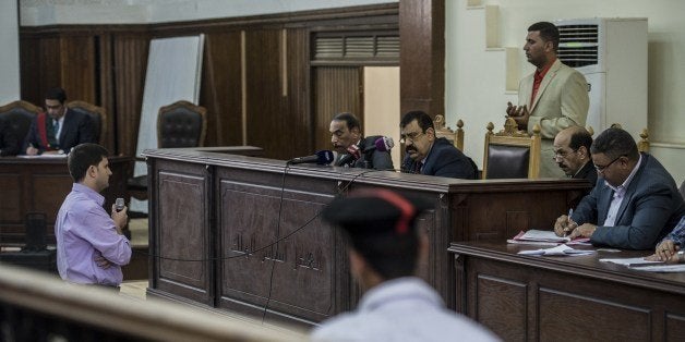 Egyptian Judge Mohame Shreen Fahmi (C) listens to a witness during the trial of Al-Jazeera channel's journalists for allegedly supporting the Muslim Brotherhood on June 1, 2014 at the police institute near Cairo's Tora prison. The high-profile case that sparked a global outcry over muzzling of the press is seen as a test of the military-installed government's tolerance of independent media, with activists fearing a return to autocracy three years after the Arab Spring uprising that toppled Hosni Mubarak. AFP PHOTO / KHALED DESOUKI (Photo credit should read KHALED DESOUKI/AFP/Getty Images)