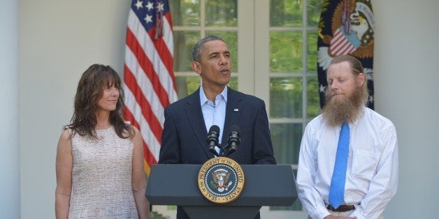 US President Barack Obama speaks during a previously unscheduled appearance in the Rose Garden of the White House on May 31, 2014 in Washington, DC. US President Barack Obama said Saturday that an American soldier held for half a decade in Afghanistan has been freed. Freed American soldier Bowe Bergdahl's parents Bob (R) and Jani Bergdahl (L) look on while President Obama speaks to the press. AFP PHOTO/Mandel NGAN (Photo credit should read MANDEL NGAN/AFP/Getty Images)