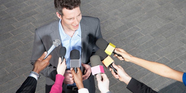 Reporters holding microphones for politician