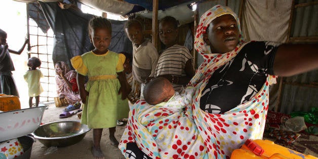(FILES) -- File picture dated 07 March 2007 shows a family preparing their meal inside their shack made of corrugated iron an