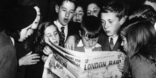 Young Scottish 'seavacuees', exiled to America for safety, eagerly catching up with news of the War in the 'Daily Mirror' aft