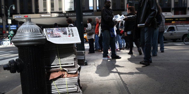 NEW YORK, NY - APRIL 16: A newspaper vendor hands out free copies of The New York Daily News ouside of Penn Station on April 16, 2013 in New York City. Police were out in force throughout New York, a day after explosions near the finish line of the Boston Marathon killed 3 people and wounded more than 170 others. (Photo by John Moore/Getty Images)