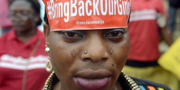 A woman with a sticker on her head bearing the slogan 'Bring back our girls' marches for the release of the more than 200 abducted Chibok school girls in Lagos on May 29, 2014, during a demonstration by civil society groups and celebrities of the film and entertainment industries to press for the girls' release, seven weeks after their abduction by Islamist militant group Boko Haram, and on the occasion of Nigeria's Democracy Day. Nigerian President Goodluck Jonathan vowed on May 29 total war against terrorism as the country's security forces stepped up efforts to rescue more than 200 schoolgirls kidnapped by Boko Haram Islamists 45 days ago. AFP PHOTO/PIUS UTOMI EKPEI (Photo credit should read PIUS UTOMI EKPEI/AFP/Getty Images)