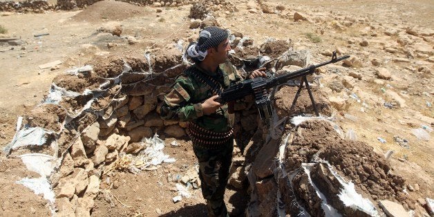 An Iraqi Kurdish Peshmerga fighter takes position on the front line in Bashiqa, a town 13 kilometres north-east of Mosul on August 12, 2014. Militants from the Islamic State of Iraq and the Levant overran Mosul and a string of Sunni Arab northern towns on Tuesday, in a major blow to the Iraqi government that the United States warned threatens the entire region. AFP PHOTO/AHMAD AL-RUBAYE (Photo credit should read AHMAD AL-RUBAYE/AFP/Getty Images)