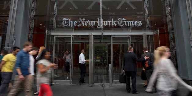 Pedestrians pass in front of The New York Times Co. offices in New York, U.S., on Wednesday, July 31, 2013. The New York Times Co. is scheduled to release earnings data on Aug. 1. Photographer: Scott Eells/Bloomberg via Getty Images