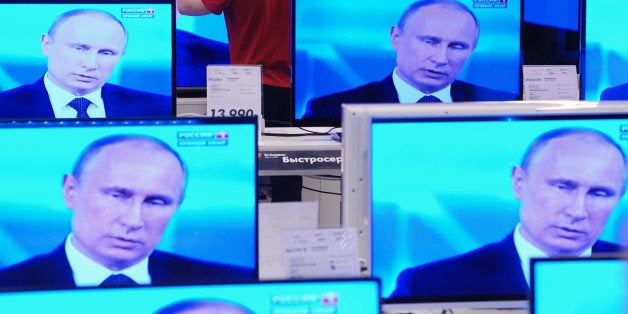 MOSCOW, RUSSIA - APRIL 17: A shop assistant cleans a TV screen during Russian President Vladimir Putin's nationally televised question and answer session in a shop on April 17, 2014 in Moscow, Russia. Putin accused today Ukraine's new authorities of driving the country towards the abyss but said that dialogue was the only way out of the intensifying crisis. (Photo Dmitri Dukhanin/Kommersant via Getty Images)