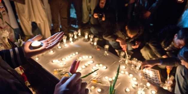 Friends and family of slain Afghan AFP reporter Sardar Ahmad attend a candle light vigil on a hill overlooking Kabul on March