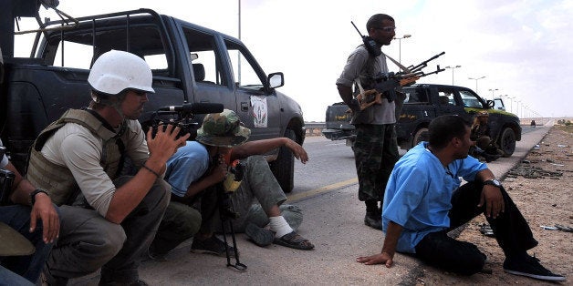 A photo taken on September 29, 2011 shows US freelance reporter James Foley (L) on the highway between the airport and the West Gate of Sirte, Libya. Foley was kidnapped in war-torn Syria six weeks ago and has been missing since, his family revealed on January 2, 2013. Foley, 39, an experienced war reporter who has covered other conflicts, was seized by armed men in the town of Taftanaz in the northern province of Idlib on November 22, according to witnesses. The reporter contributed videos to Agence France-Presse (AFP) in recent months. AFP PHOTO / ARIS MESSINIS (Photo credit should read ARIS MESSINIS/AFP/Getty Images)