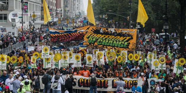 Demonstrators hold signs on a street next to Central Park during the People's Climate March in New York, U.S., on Sept. 21, 2014. The United Nations 2014 Climate Summit is scheduled for Sept. 23. Photographer: Timothy Fadek/Bloomberg via Getty Images