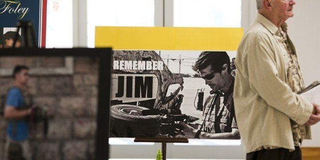 A parishioner walks past a display of photos of James Foley before a Catholic mass at Our Lady of the Holy Rosary Parish August 24, 2014 in Rochester, New Hampshire. The family and friends of murdered US journalist James Foley are attending the memorial mass and offering prayers for the safety of his fellow hostages in Syria. AFP PHOTO/DOMINICK REUTER (Photo credit should read DOMINICK REUTER/AFP/Getty Images)