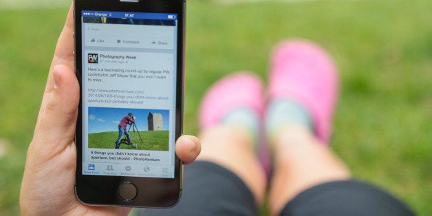 Girl lay on backyard house grass checking internet with smartphone.