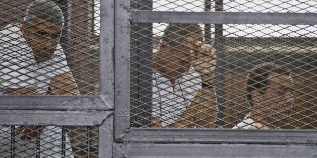 Mohammed Fahmy, Canadian-Egyptian acting bureau chief of Al-Jazeera, from left, Australian correspondent Peter Greste and Egy