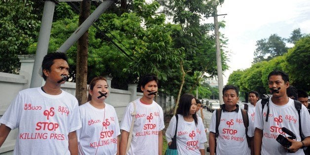 Myanmar journalists wearing T-shirts that say 'Stop Killing Press' stage a silent protest for five journalists who were jailed for 10 years on July 10, near the Myanmar Peace Center where Myanmar President Thein Sein was scheduled to meet with local artists in Yangon on July 12, 2014. Myanmar jailed five journalists to 10 years in prison with hard labour on July 10 over a report accusing the military of producing chemical weapons, a sentence denounced by campaigners as 'outrageously harsh'. Reporters Without Borders described the verdict as 'very worrying for press freedom' in Myanmar. AFP PHOTO / SOE THAN WIN (Photo credit should read Soe Than WIN/AFP/Getty Images)