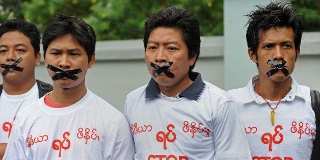 Myanmar journalists wearing T-shirts that say 'Stop Killing Press' stage a silent protest for five journalists who were jailed for 10 years on July 10, near the Myanmar Peace Center where Myanmar President Thein Sein was scheduled to meet with local artists in Yangon on July 12, 2014. Myanmar jailed five journalists to 10 years in prison with hard labour on July 10 over a report accusing the military of producing chemical weapons, a sentence denounced by campaigners as 'outrageously harsh'. Reporters Without Borders described the verdict as 'very worrying for press freedom' in Myanmar. AFP PHOTO / SOE THAN WIN (Photo credit should read Soe Than WIN/AFP/Getty Images)