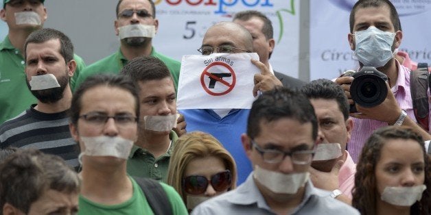 Journalists from different media protest for the murder of colleague Luis Carlos Cervantes in Medellin, Antioquia department, Colombia on August 13, 2014. Cervantes was killed last Tuesday by criminal gangs in Taraza, Antioquia department, after the government withdrew its security scheme fifteen days ago, following threats from outlaw groups. AFP PHOTO/Raul ARBOLEDA (Photo credit should read RAUL ARBOLEDA/AFP/Getty Images)