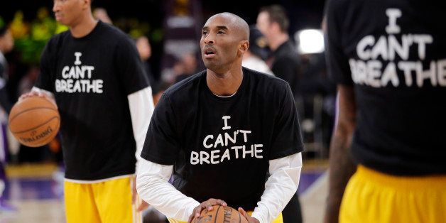 Los Angeles Lakers' Kobe Bryant, center, warms up before an NBA basketball game against the Sacramento Kings, Tuesday, Dec. 9, 2014, in Los Angeles. Several athletes have worn "I Can't Breathe" shirts during warm ups in support of the family of Eric Garner, who died July 17 after a police officer placed him in a chokehold when he was being arrested for selling loose, untaxed cigarettes. (AP Photo/Jae C. Hong)