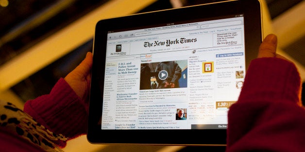 An Apple Inc. iPad tablet computer with the New York Times website displayed is held up for an illustration in New York, U.S., on Thursday, Jan. 20, 2011. New York Times Co. will charge readers less than $20 a month for full access to its namesake newspaper on the Web when the company introduces its paid service, a person familiar with the matter said. Photographer: Andrew Harrer/Bloomberg via Getty Images