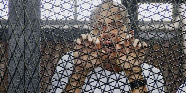 FILE - In this Saturday, May 3, 2014 file photo, Al-Jazeera's award-winning Australian correspondent Peter Greste, appears in a defendants' cage in a courthouse near Tora prison in Cairo, Egypt. An Egyptian court on Monday, June 23, 2014, convicted three Al-Jazeera journalists and sentenced them to seven years in prison on terrorism-related charges after a trial dismissed by rights groups as a politically motivated sham. The verdict brought a landslide of international condemnation and calls for Egyptian President Abdel-Fattah el-Sissi to intervene. El-Sissi, on Tuesday said he will not interfere in court rulings, sparking an international outcry. (AP Photo/Hamada Elrasam, File)