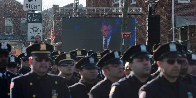 Police officers turn their backs as New York City Mayor Bill de Blasio speaks at the funeral of New York city police officer Rafael Ramos in the Glendale section of Queens, Saturday, Dec. 27, 2014, in New York. Ramos and his partner, officer Wenjian Liu, were killed Dec. 20 as they sat in their patrol car on a Brooklyn street. The shooter, Ismaaiyl Brinsley, later killed himself. (AP Photo/John Minchillo)