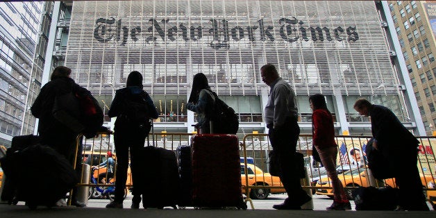 Pedestrians wait for cabs across the street from The New York Times on Wednesday, May 14, 2014, in New York. The New York Tim