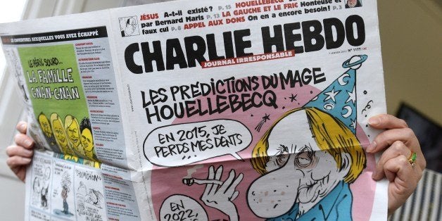 A person reads the latest issue of the French satirical newspaper Charlie Hebdo in Paris on January 7, 2015, after gunmen armed with Kalashnikovs and a rocket-launcher opened fire in the offices of the weekly in Paris, killing at least 11. AFP PHOTO / BERTRAND GUAY (Photo credit should read BERTRAND GUAY/AFP/Getty Images)