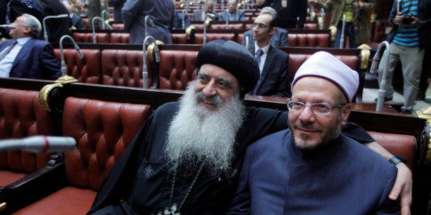 CORRECTS NAME OF BISHOP - Egypt's Grand Mufti Shawqi Allam, right, and a representative of the Orthodox church Bishop Bola, pose for a picture before they begin voting on a series of constitutional amendments, in the Shoura Council, Cairo, Egypt, Saturday, Nov. 30, 2013. The 50-member committee will hand in the draft constitution to interim Egyptian President Adly Mansour, who has a month to call for a public vote on it. (AP Photo/Amr Nabil)