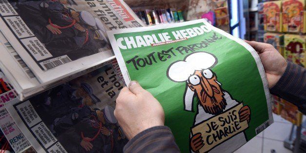 A man displays the latest edition of French satirical magazine Charlie Hebdo shortly after it went on sale on January 14, 2015 in Montpellier. The first issue of satirical magazine Charlie Hebdo to be published since a jihadist attack decimated its editorial staff last week was sold out within minutes at kiosks across France. AFP PHOTO / PASCAL GUYOT (Photo credit should read PASCAL GUYOT/AFP/Getty Images)