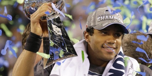 Quarterback Russell Wilson (3) hoists the Lombardi trophy after a 43-8 victory against the Denver Broncos in Super Bowl XLVII