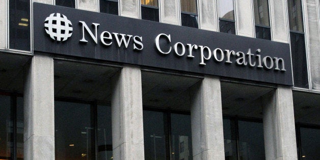 FILE - In this Oct. 12, 2011 file photo, people walk in front of the News Corporation building in New York. News Corp. said Tuesday, Nov. 6, 2012, that net income for the latest quarter tripled from a year ago, reflecting a one-time gain from the sale of its stake in digital video technology company NDS. Revenue rose 2 percent thanks to growth at pay TV networks such as Fox News Channel. AP Photo/Kathy Willens, File)