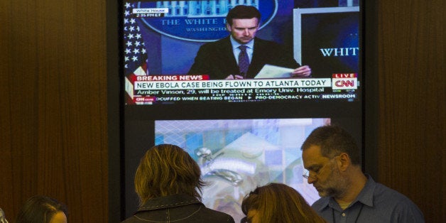 ATLANTA, GA - OCTOBER 21: Staff members inside the CDC's (Centers for Disease Control and Prevention) Emergency Operations Response Center huddle under a large TV screen showing a White House press briefing playing on CNN on Wednesday, October 15, 2014 in Atlanta, Georgia. The staff is responding to the Ebola crisis 24 hours per day; the CDC has become the central figure in the administration responsible for coordinating the Ebola crisis (Photo by Michel du Cille/The Washington Post via Getty Images)