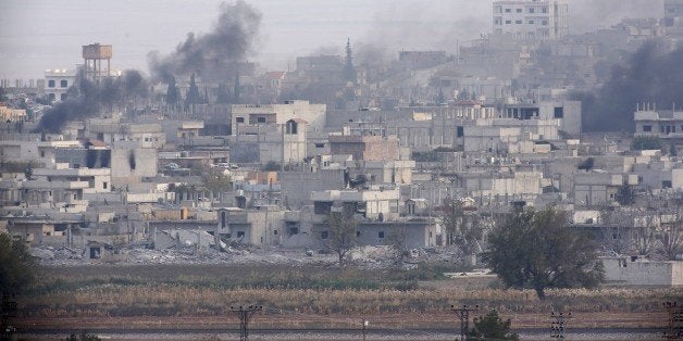 SANLIURFA, TURKEY - NOVEMBER 14: Smoke, rising from Kobani (Ayn al-Arab) town of northern Syria during the missile and mortar attacks between Islamic State of Iraq and Levant (ISIL) and Kurdish armed groups near Syrian-Turkish border crossing, is seen from Suruc district of Turkey's Sanliurfa on November 14, 2014. (Photo by Ali Ihsan Ozturk/Anadolu Agency/Getty Images)