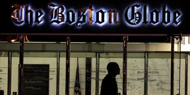 A security guard walks past the entrance of the Boston Globe headquarters in the Dorchester neighborhood of Boston, Monday July 20, 2009. Reporters and editors at The Boston Globe were considering for a second time Monday whether to give up $10 million in annual wages and benefits to bolster the struggling newspaper. The Boston Globe's largest union tonight decisively approved a package of major concessions, including $10 million in wage and benefit cuts, ratifying the new contract by a vote of 366 to 179. (AP Photo/Charles Krupa)