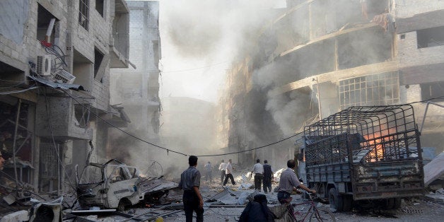 DAMASCUS, SYRIA - SEPTEMBER 11: Syrians are seen around an attacked area after Asad regime forces' airstrikes killed at least 50 people, including children and women, and injured more than 200 others in Douma district of Damascus, Syria on September 11, 2014. (Photo by Yousef Albostany/Anadolu Agency/Getty Images)