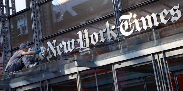 A man polishes the sign for The New York Times at the company's headquarters, July 18, 2013 in New York. The newspaper has faced declines in print advertising and subscription revenue. The company has tried to offset those drops by increasing the number of digital subscribers. (AP Photo/Mark Lennihan)