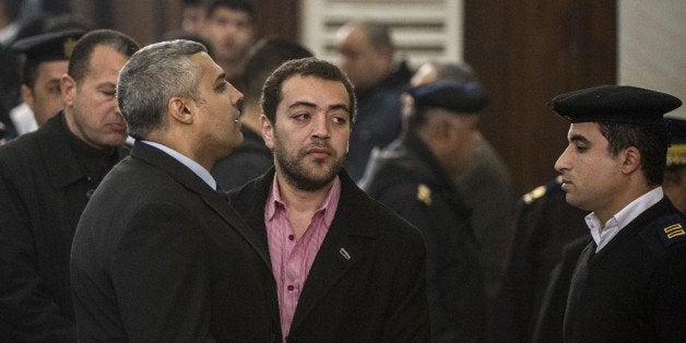 Al-Jazeera's Egyptian producer Baher Mohamed (C) and Egyptian-Canadian reporter Mohamed Fadel Fahmy (L) attend their trial at