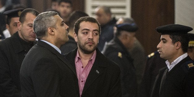 Al-Jazeera's Egyptian producer Baher Mohamed (C) and Egyptian-Canadian reporter Mohamed Fadel Fahmy (L) attend their trial at the Tora prison in the capital Cairo on February 23, 2015. The Egyptian court postponed the trial of the two Al-Jazeera journalists to March 8, 2015, with Canadian reporter Fahmy saying he hoped for a fair hearing in a case that sparked global criticism. AFP PHOTO / KHALED DESOUKI (Photo credit should read KHALED DESOUKI/AFP/Getty Images)