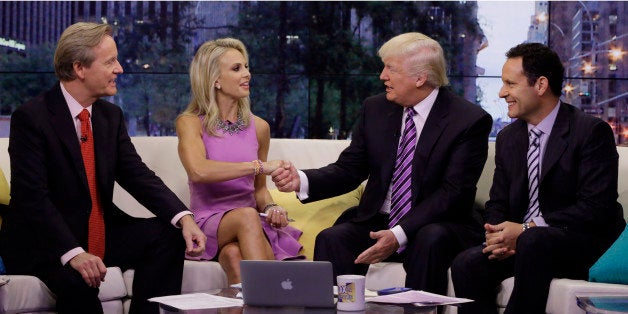 Elisabeth Hasselbeck appears with co-hosts Steve Doocy, left, and Brian Kilmeade, right, as Donald Trump is interviewed during her debut on the "Fox & Friends" television program, in New York Monday, Sept. 16, 2013. The former cast member of "The View" replaced Gretchen Carlson. (AP Photo/Richard Drew)