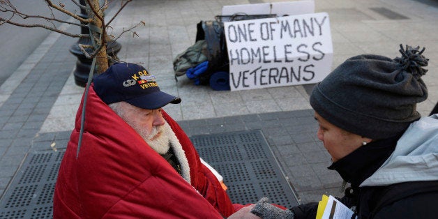 In this Wednesday, Nov. 20, 2013 photo, homeless Korean War veteran Thomas Moore, 79, left, speaks with Boston Health Care for the Homeless street team outreach coordinator Romeena Lee on a sidewalk in Boston. Moore, who said he accidentally killed his best friend with a phosphorous grenade during one firefight and spent months afterward at Walter Reed Army Medical Center in Washington, also said he has no interest in getting a government-subsidized apartment. (AP Photo/Steven Senne)