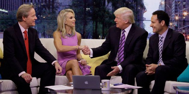 Elisabeth Hasselbeck appears with co-hosts Steve Doocy, left, and Brian Kilmeade, right, as Donald Trump is interviewed during her debut on the "Fox & Friends" television program, in New York Monday, Sept. 16, 2013. The former cast member of "The View" replaced Gretchen Carlson. (AP Photo/Richard Drew)