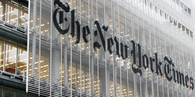 People pass the New York Times building in New York, Wednesday, Oct. 10, 2012. The New York Times Co.'s stock rose on Thursday, Oct. 11, 2012, after an analyst raised his rating and price target on the shares. (AP Photo/Richard Drew)