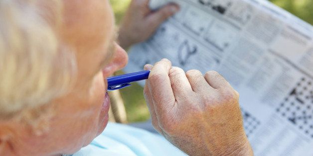 Senior man reading newspaper outside