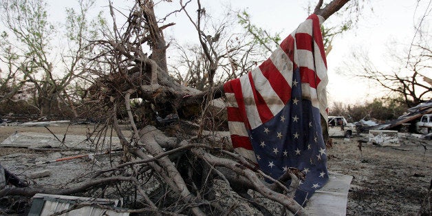 PORT SULPHUR, LA - SEPTEMBER 11: An American flag hangs in a pile of debris after Hurricane Katrina passed through September 11, 2005 in Port Sulphur, Louisiana. Most of the homes throughout the Plaquemines parish are destroyed or heavily damaged. (Photo by Joe Raedle/Getty Images)