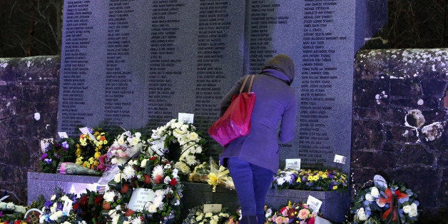 A member of the public looks on at the main memorial stone in memory of the victims of Pan Am flight 103 bombing, in the garden of remembrance at Dryfesdale Cemetery, near Lockerbie, Scotland. Saturday Dec. 21, 2013. Pan Am flight 103 was blown apart above the Scottish border town of Lockerbie on Dec. 21, 1988. All 269 passengers and crew on the flight and 11 people on the ground were killed in the bombing. (AP Photo/Scott Heppell).