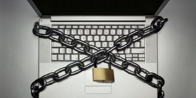 Laptop locked with chain, close-up, overhead view, (digital composite)