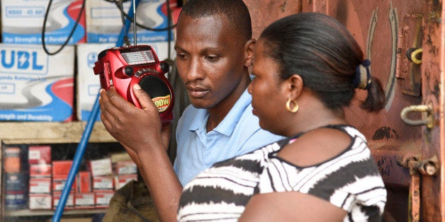 People listen to the radio as the results of the presidential elections are announced in Kireka, a Kampala suburb on February