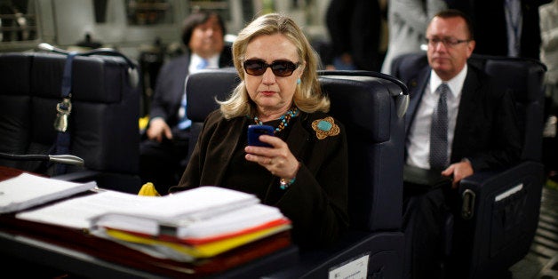 U.S. Secretary of State Hillary Clinton checks her PDA upon her departure in a military C-17 plane from Malta bound for Tripoli, Libya October 18, 2011. REUTERS/Kevin Lamarque (LIBYA - Tags: POLITICS) FOR BEST QUALITY IMAGE ALSO SEE: GF2EA1P10ZY01