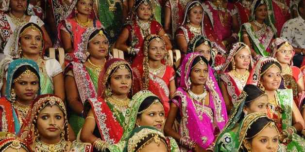 This photo taken on December 6, 2015 shows brides at a mass-marriage ceremony for 151 fatherless women, in Surat, around 265 km from Ahmedabad. An Indian diamond trader has thrown a mass wedding ceremony for 151 fatherless women, saying giving a bride away was 'sacred'. AFP PHOTO / AFP / STR (Photo credit should read STR/AFP/Getty Images)