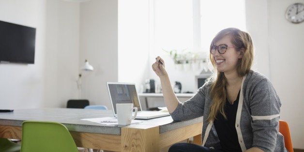 Smiling businesswoman at laptop in office