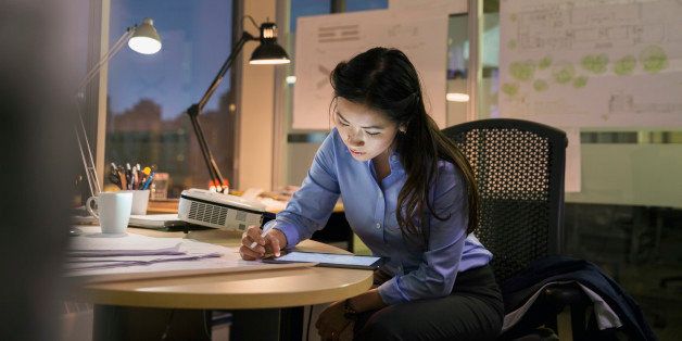 Businesswoman with digital tablet working late in office