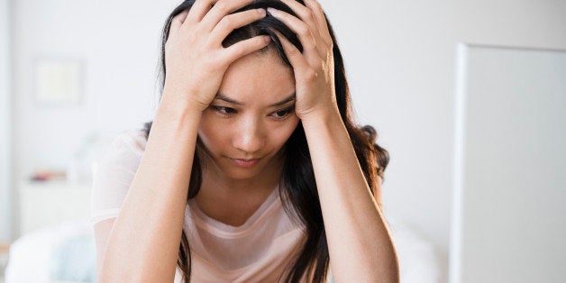 Frustrated Chinese woman using laptop